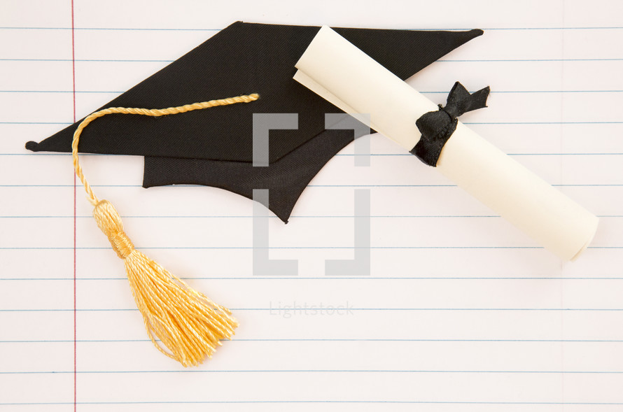 diploma and graduation cap on lined paper 