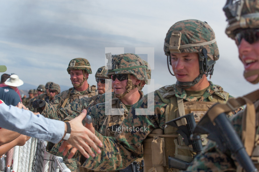 shaking hands with service members 