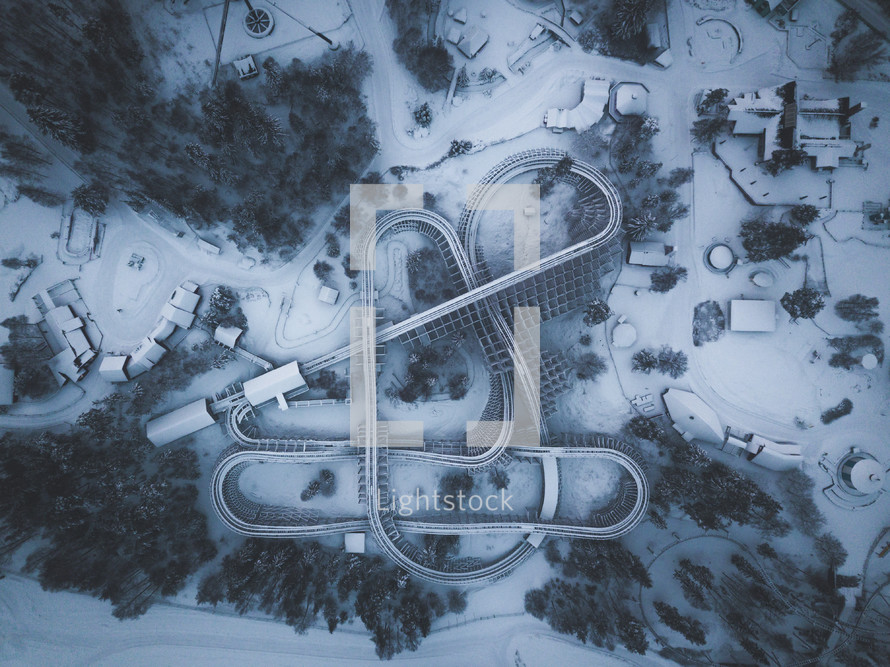 aerial view over a roller coaster covered in snow 