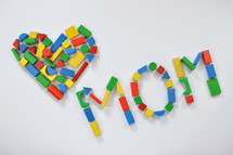 wooden blocks in the shape of a heart and the word mom 