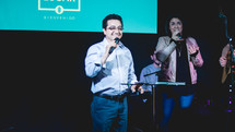 worship leaders with microphones on stage 