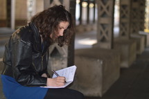 a woman writing in a journal 