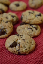 chocolate chips cookies on a red cloth