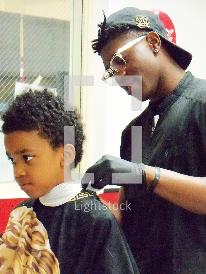 A young boy gets a hair cut at a local church... — Photo — Lightstock