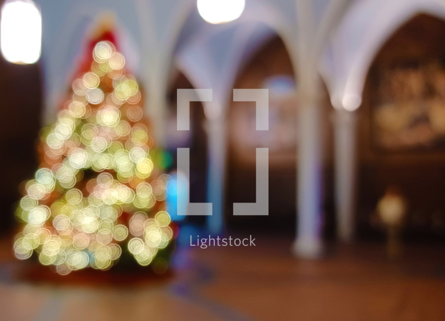Blurry background with Christmas tree and bokeh lights in a church