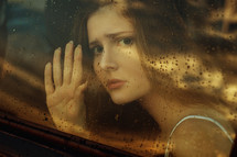 face of a woman looking through a car window 
