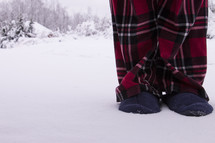 Man with slippers and pajamas standing in snow