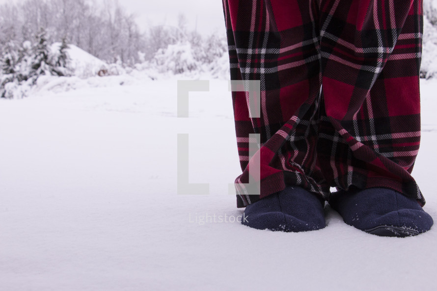 Man with slippers and pajamas standing in snow