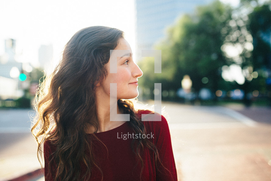 side profile of a woman standing down town 
