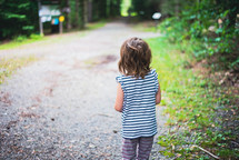 girl walking on a gravel path 
