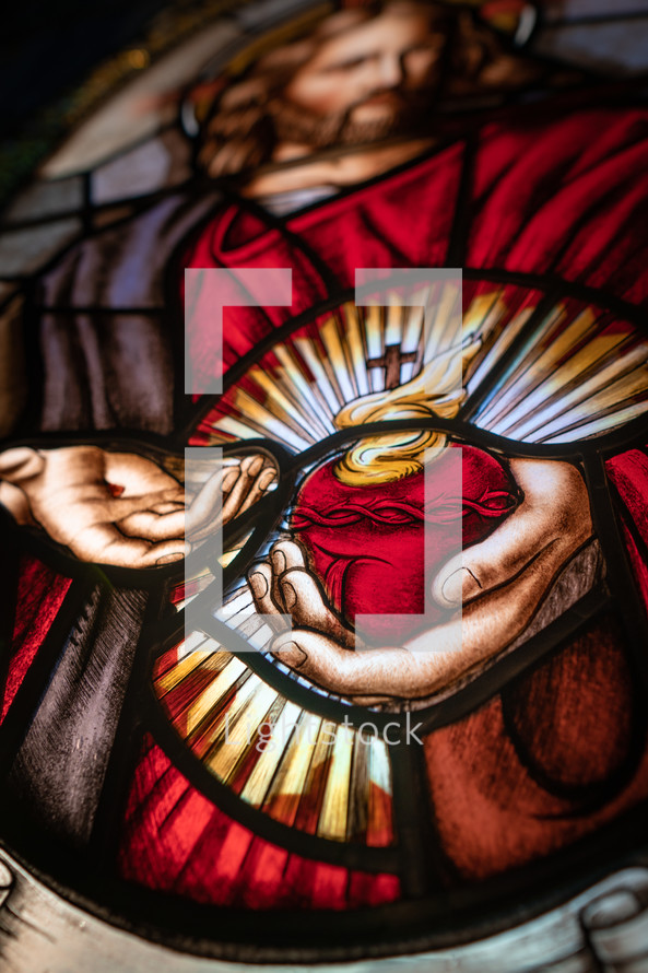 Close up of stained glass window of Flaming Sacred Heart. 