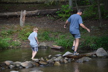 father and son exploring a stream 