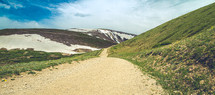 dirt path and malting snow on a mountain 