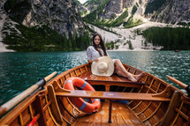 a woman sitting on the stern of a rowboat 