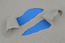 craft paper ripped open at two places showing blank light blue paper below with space for a message
