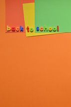 The words BACK TO SCHOOL with magnetic letters on colorful paperboard