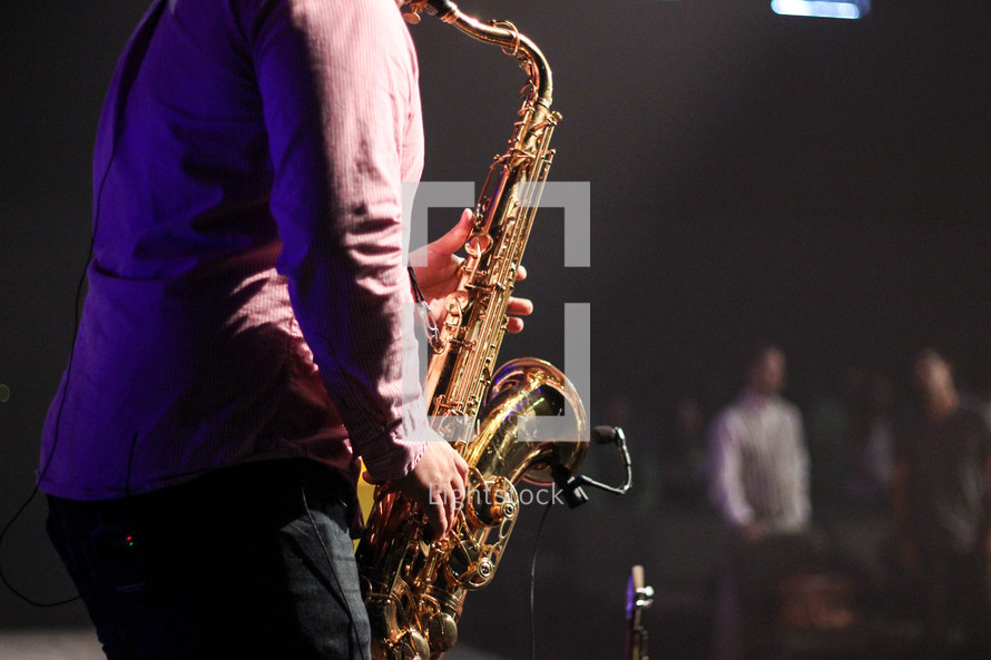 a man playing a saxophone on stage 