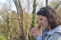 a woman in prayer outdoors 