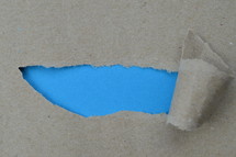 ripped paper revealing blue blank space for words