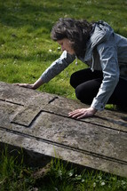 grieving woman at a gravesite 