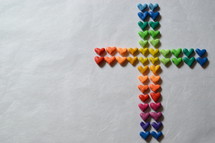 Many small, different colored hearts in the shape of a cross