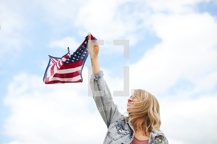 a young woman holding an American flag bandana 