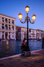 a couple standing under a street lamp in Venice 