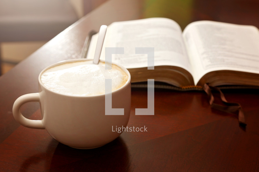 open Bible and coffee on a wood table 