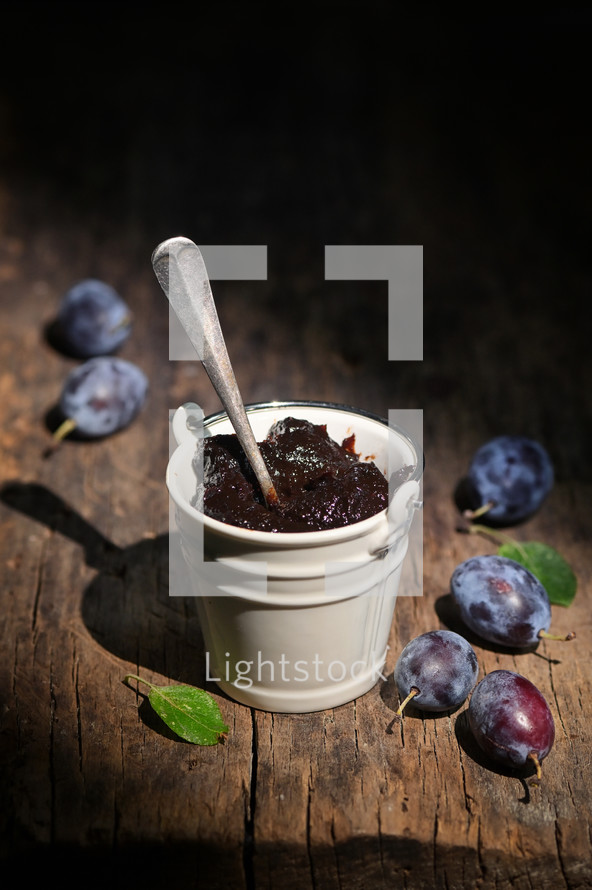 Bucket Of Thick Plum Jam on wooden table