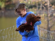 a boy catching a chicken 
