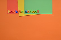 The words BACK TO SCHOOL with magnetic letters on colorful paperboard