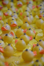 a lot of bath ducks swimming in a basin
