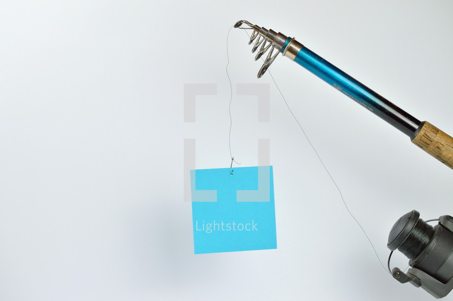  a blank piece of cyan paper at the fishhook of an angling rod