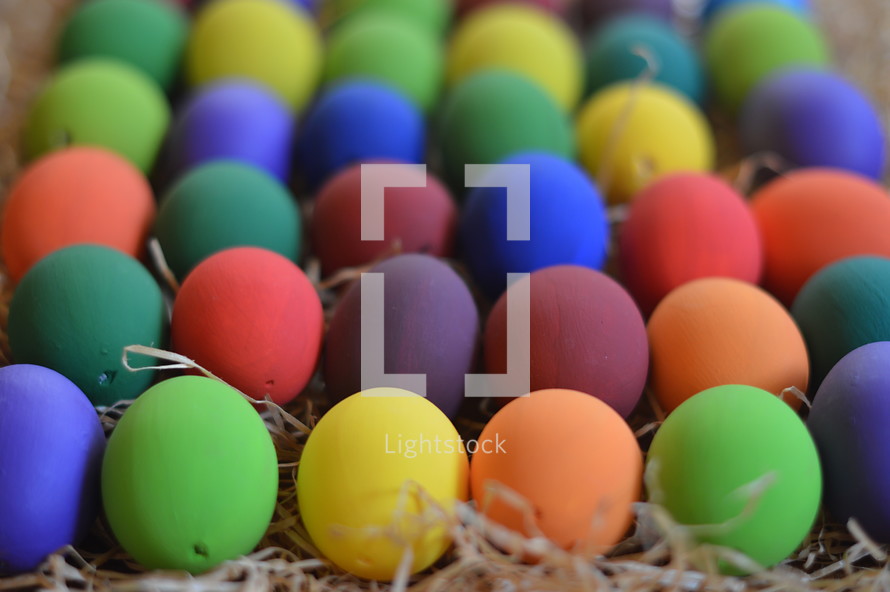 Colorfully painted Easter eggs on straw.
