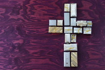 many little presents shaping a cross on purple wooden background
