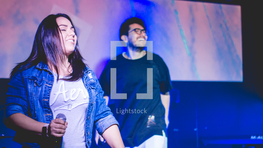 worship leaders singing into microphones 
