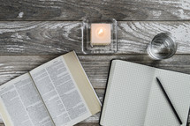 candle, notebook, Bible, and glass
