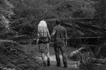 a couple walking holding hands in a park  - on the way as a couple.