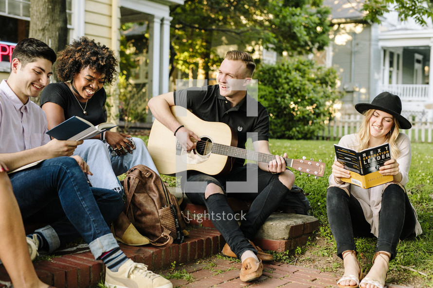 man playing a guitar outdoors at a Bible study 
