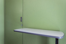 table and green doors in a hospital room 