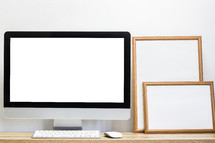 blank computer screen and framed signs 