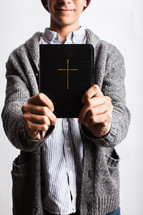 a man holding out a Bible 