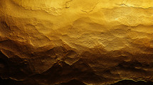Gold textured background with dramatic lighting. 