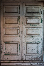 Old door with cracked and peeling white paint