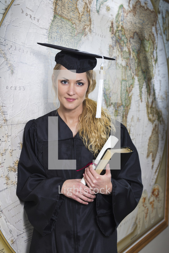 college student standing in her cap and gown at graduation 
