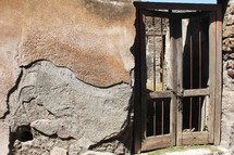 Wooden gate with a chain lock on a stone building.