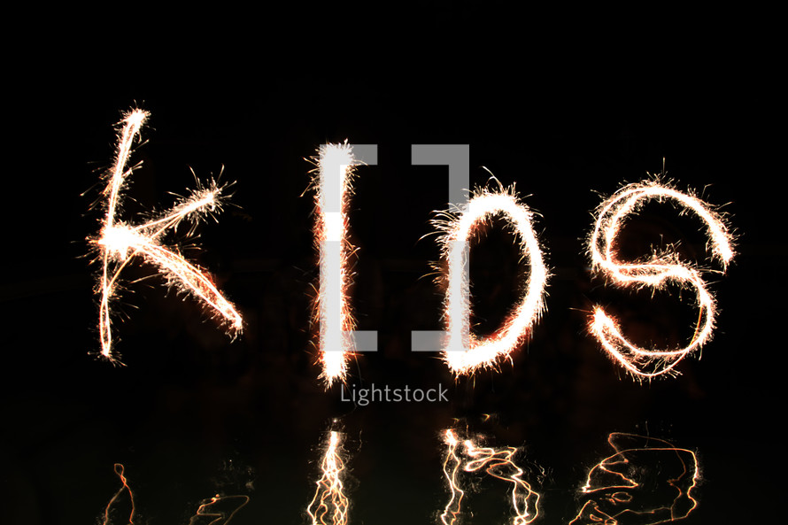 "Kids" written in fireworks (by four 'artists' standing waist high in water).