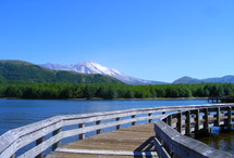 Walking bridge over a lake with Mt. St Helens Volcano in the background
