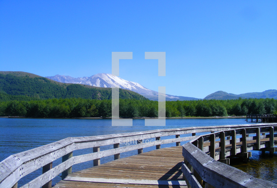 Walking bridge over a lake with Mt. St Helens Volcano in the background