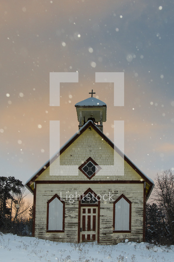 snow falling around a rural church 